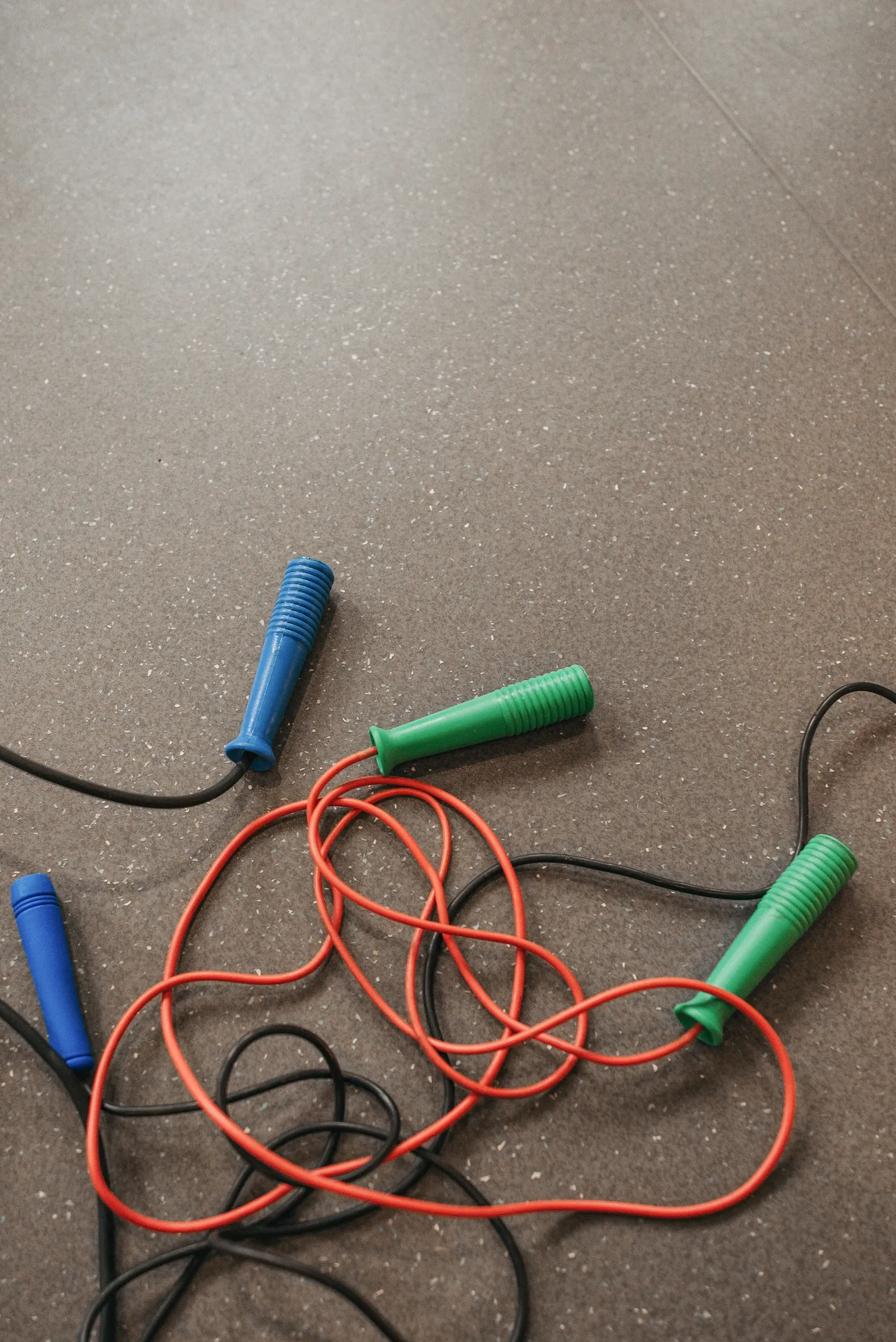 Assorted skipping ropes laid out on a gym floor